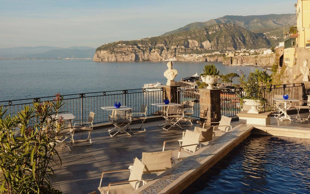 Luxurious seaside hotel with elegant Mediterranean architecture overlooking the azure coastline of Sorrento, featuring ornate balconies and panoramic ocean views