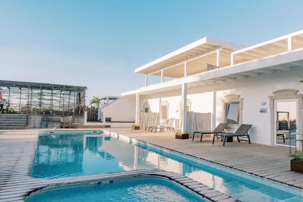 Rustic wooden terrace overlooking lush Portuguese countryside with elegant white villa, vibrant green landscape, and traditional architectural charm