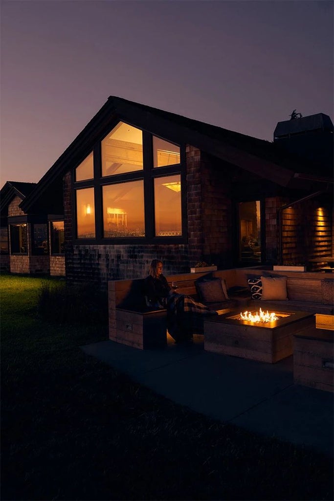 Luxurious coastal retreat overlooking Bodega Bay, featuring rustic wood-paneled exterior, expansive windows, and serene Pacific Ocean landscape beyond