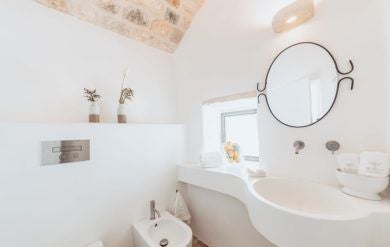 Luxurious stone Lamia suite at Borgo Canonica, featuring traditional white-washed walls, elegant rustic decor, and soft natural lighting in a serene Italian countryside setting