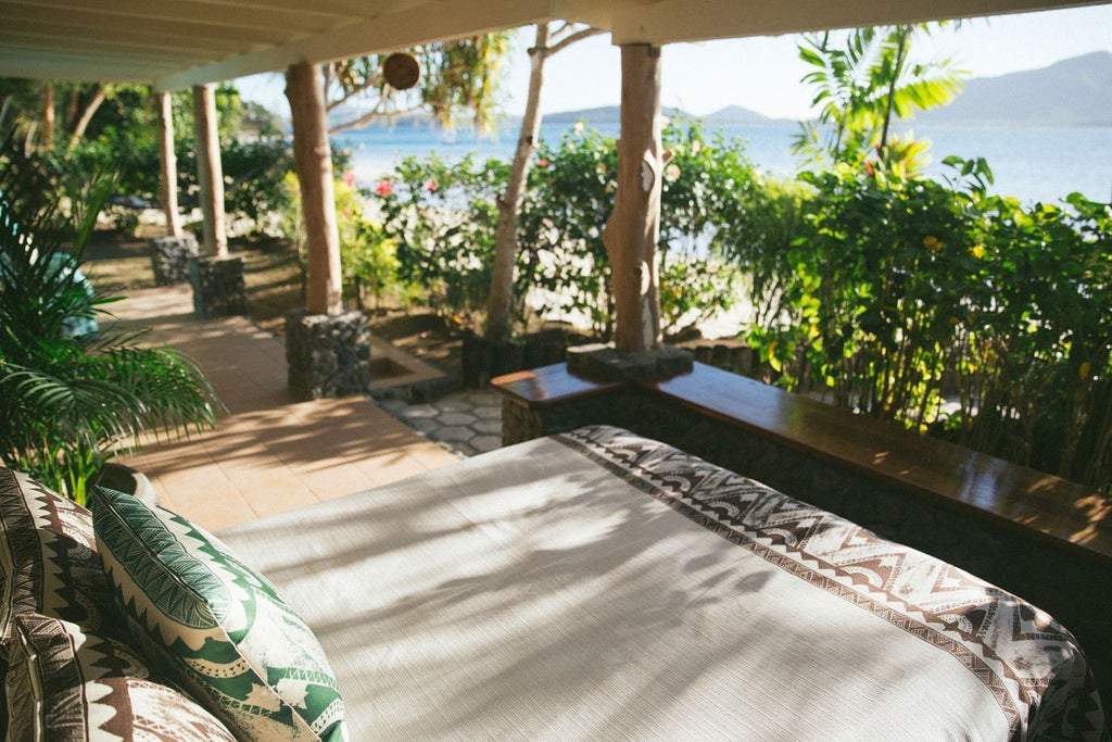 Luxurious Fijian beachfront villa with traditional thatched roof, panoramic ocean views, and elegant wooden decor showcasing Turtle Island's serene Vonu Point setting