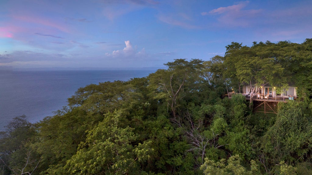 Luxurious tented suite overlooking Pacific Ocean, nestled in Costa Rican rainforest with private wooden deck and panoramic views