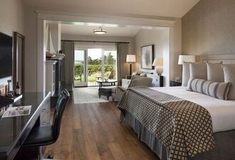 Luxurious captain's suite at The Lodge near coastal scenery, featuring elegant maritime-inspired decor with plush bedding and sweeping ocean view windows