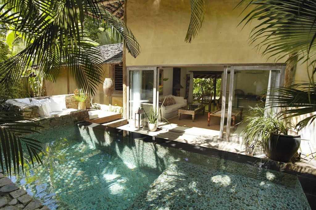 Luxurious Brazilian hotel room with rustic wooden furnishings, white linens, and tropical greenery, showcasing elegant minimalist design at UXUA Casa Hotel and Spa