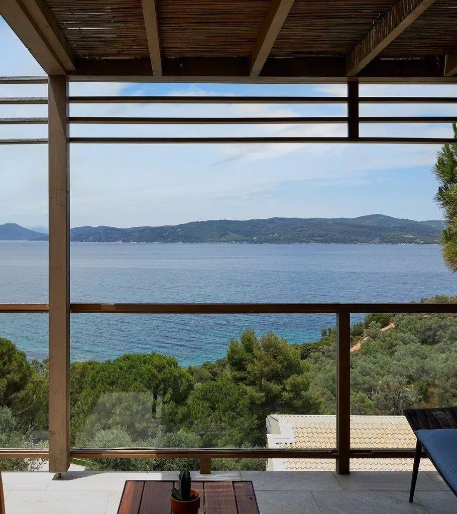 Luxurious junior suite with private hot tub overlooking Aegean Sea, featuring modern Greek design and elegant white and blue coastal decor at ELIVI Skiathos resort