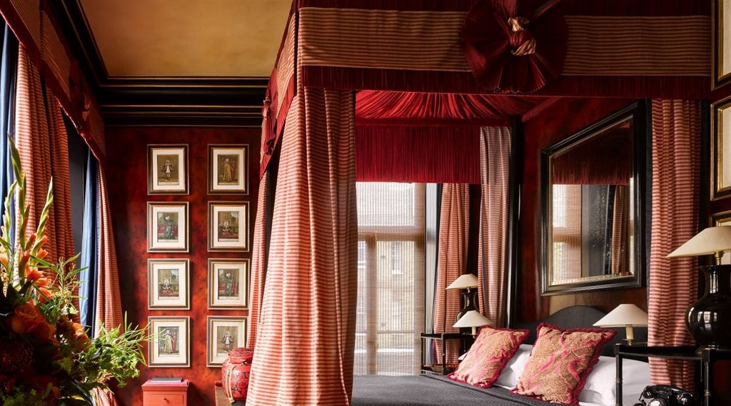 Elegant boutique hotel facade with Victorian-era architecture, ornate windows, and luxurious dark red exterior in central London setting