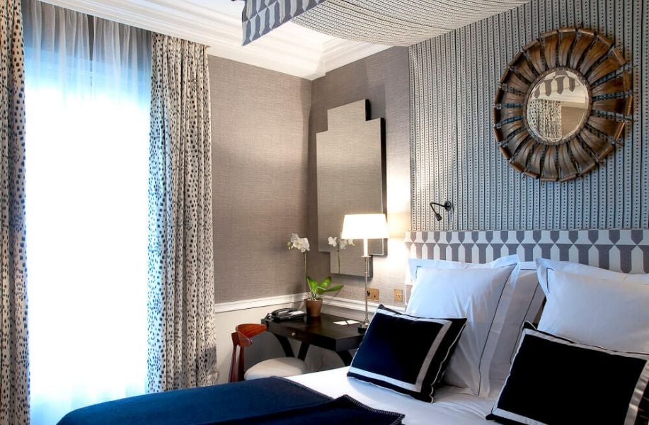 Elegant Deluxe room at Hôtel Récamier with soft neutral tones, plush bedding, modern French design, and sophisticated Parisian architectural details