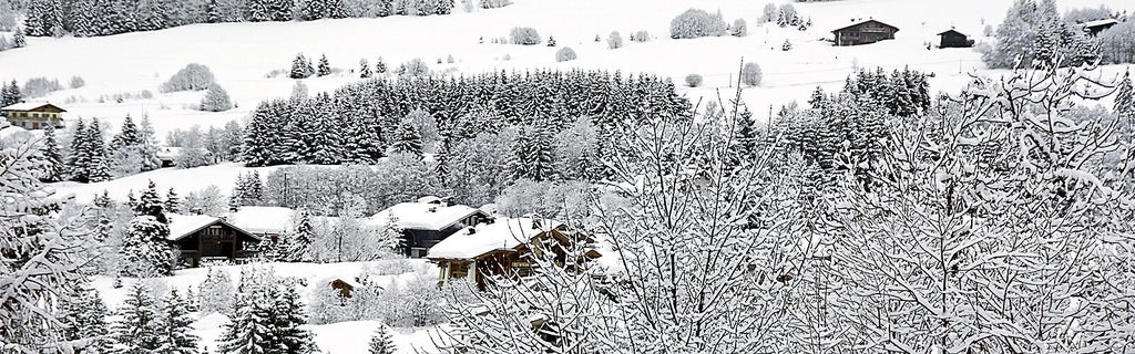 Luxurious alpine chalet with snow-capped mountains, warm wooden exterior, and cozy balconies nestled in a serene French winter landscape