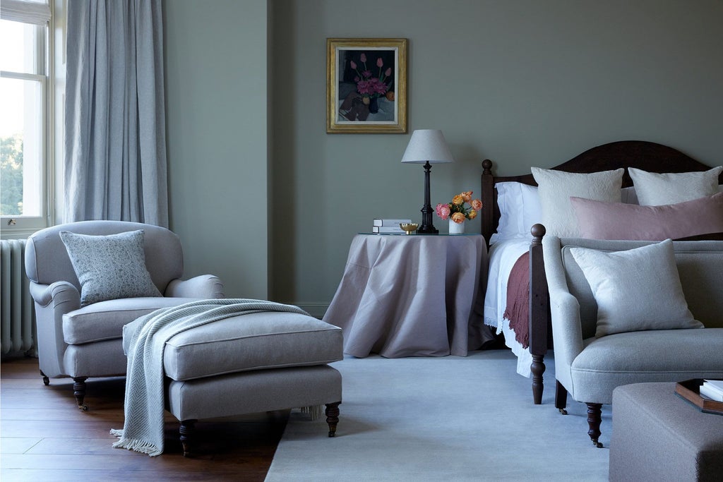 Elegant long room at Heckfield Place luxury hotel, featuring soft neutral tones, refined wooden furnishings, and expansive natural light from large windows