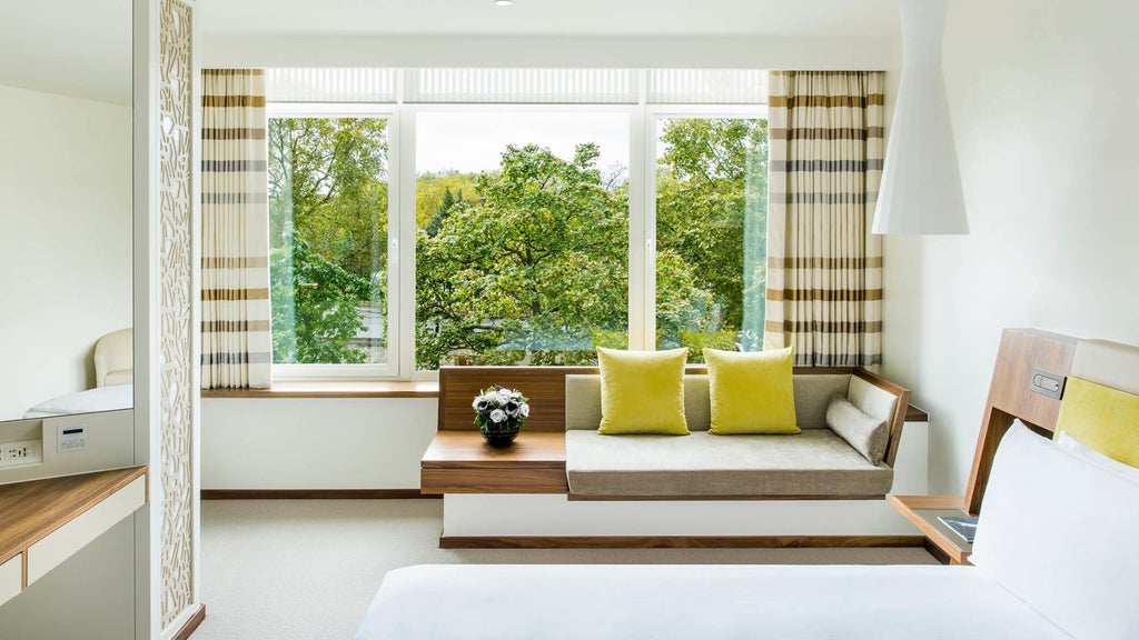 Elegant COMO Suite with plush white bedding, modern minimalist design, city view windows, and sophisticated contemporary luxury furnishings in London hotel room