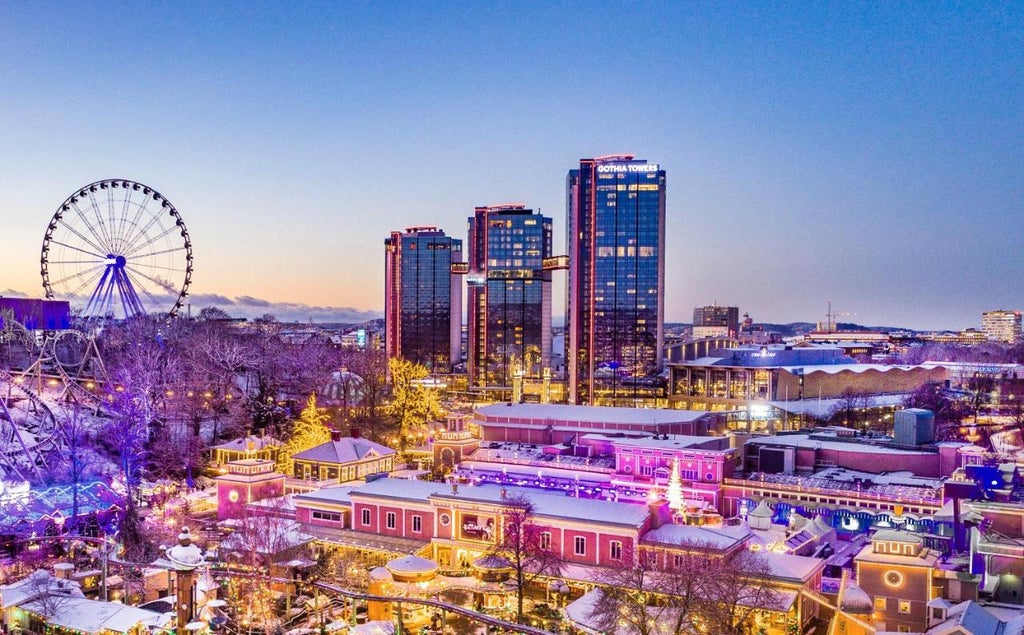 Contemporary Nordic hotel exterior with sleek glass facade, illuminated by warm lighting at dusk, surrounded by pristine snowy landscape