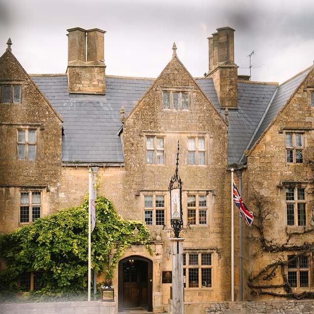 Historic 16th-century luxury hotel with elegant stone facade, Tudor-style architecture, and charming courtyard set in the scenic Cotswolds, United Kingdom.