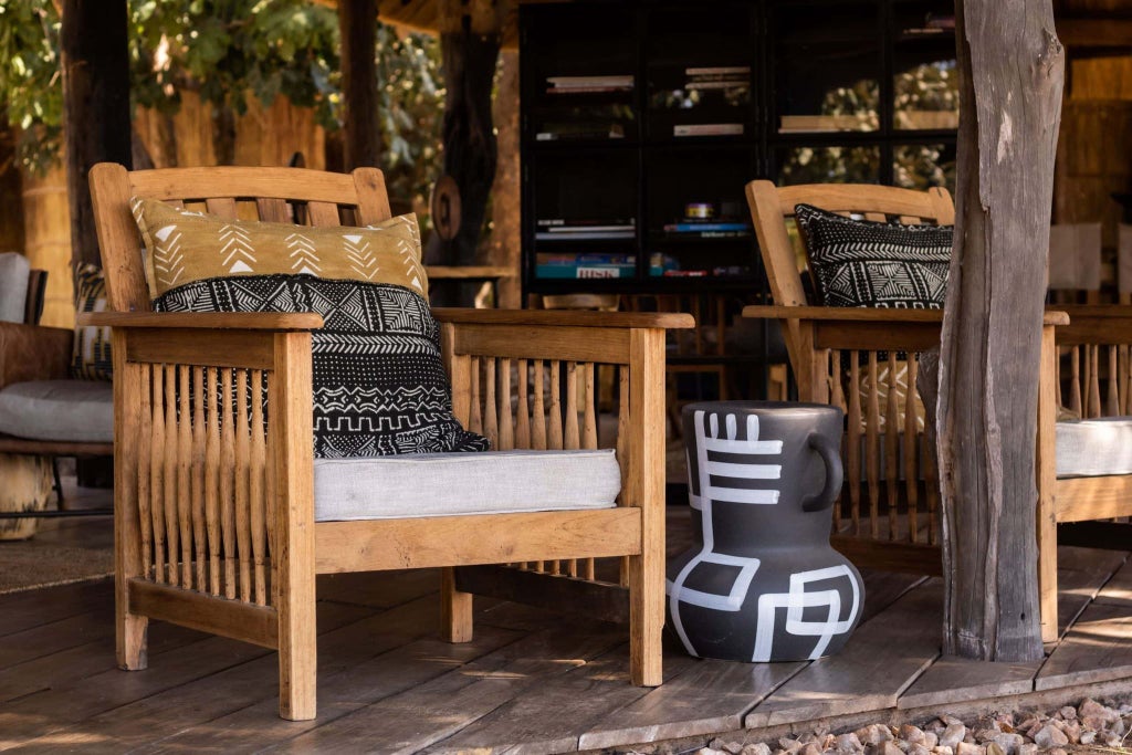 Luxurious safari lodge nestled in South Luangwa National Park, with tented canvas suites overlooking a serene river and lush wilderness landscape