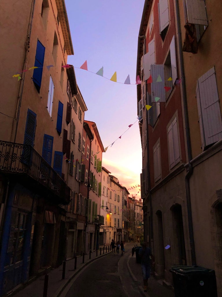 Historic fountain in Aix-en-Provence surrounded by elegant 17th-century buildings and charming cafes under golden Mediterranean light