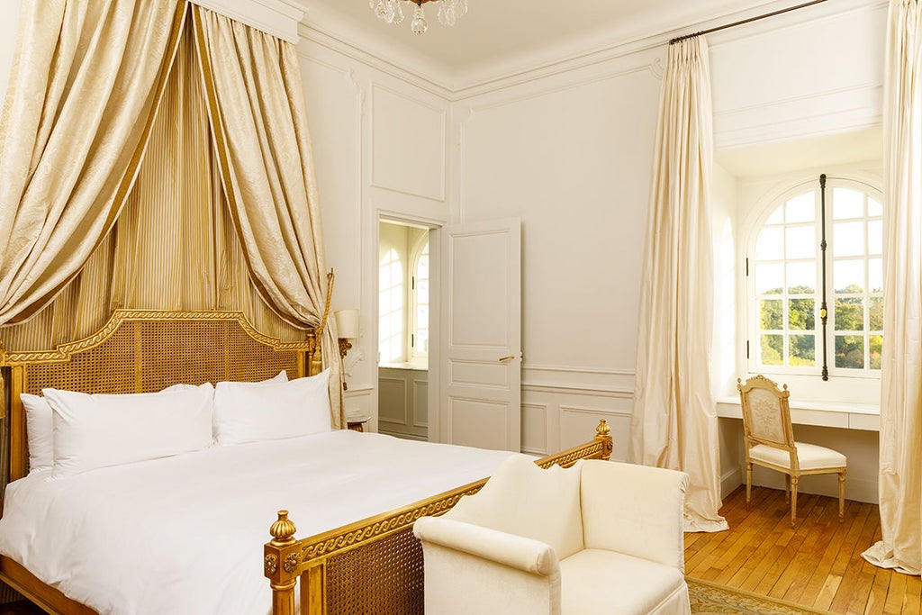 Elegant top-floor corner suite with French windows, antique furnishings and garden views at historic Château du Grand-Lucé hotel