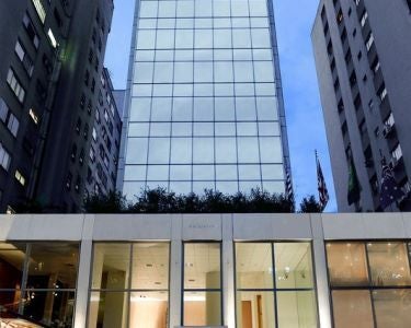 Luxurious modern hotel facade with sleek glass and steel design, situated in the heart of São Paulo's upscale urban landscape at dusk