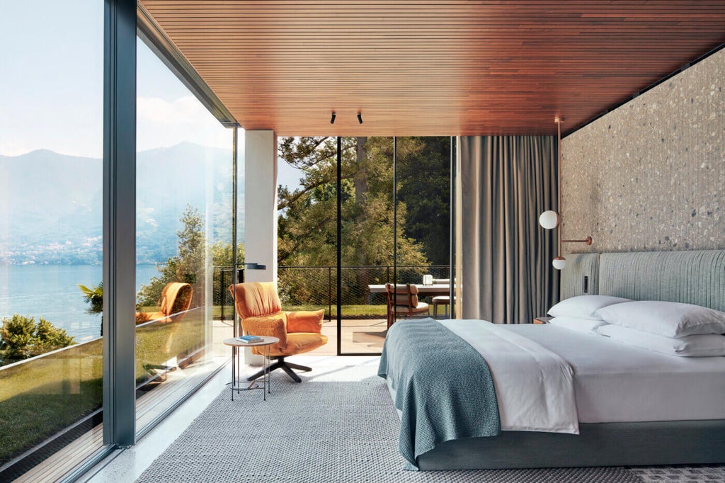 Modern luxury hotel with floor-to-ceiling windows overlooking Lake Como, featuring sleek wood terraces and infinity pool at sunset