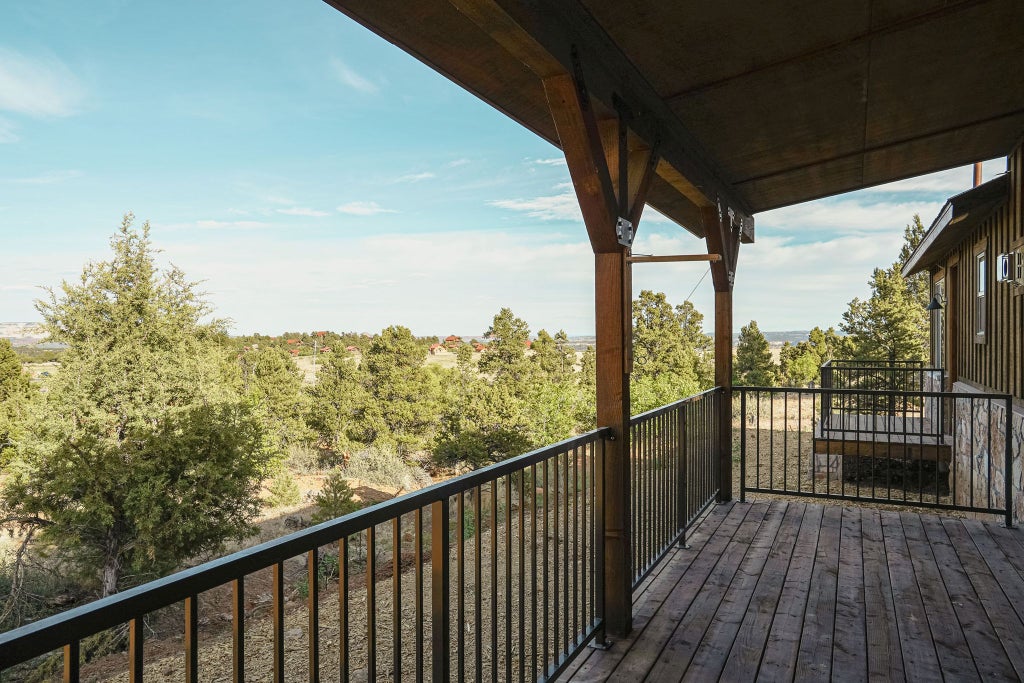 Rustic lodge bedroom with wooden furnishings, panoramic mountain views, plush bedding, and warm ambient lighting in a cozy retreat near a national park.