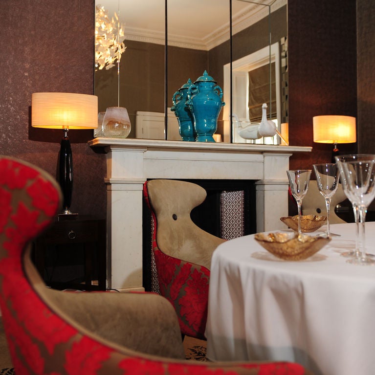 Historic Georgian townhouse with elegant dining room featuring crystal chandeliers, white-clothed tables, and restored period details