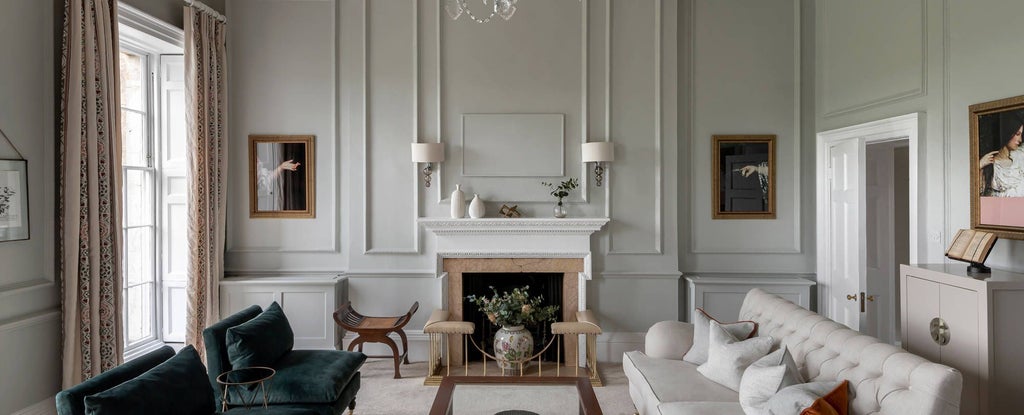 Elegant master suite with plush king bed, antique furnishings, soft neutral color palette, and large arched windows overlooking historic Bath architecture