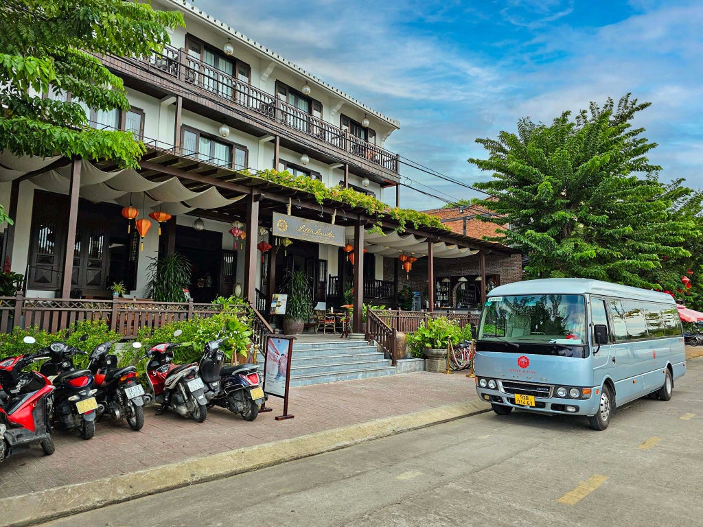 Luxurious Vietnamese boutique hotel with traditional architecture, lush tropical gardens, and elegant white exterior in Hoi An's historic district