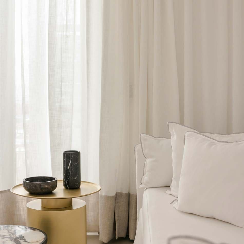 Luxurious white-washed junior suite with private plunge pool overlooking azure Aegean Sea, featuring minimalist Cycladic design and modern elegance in Mykonos, Greece