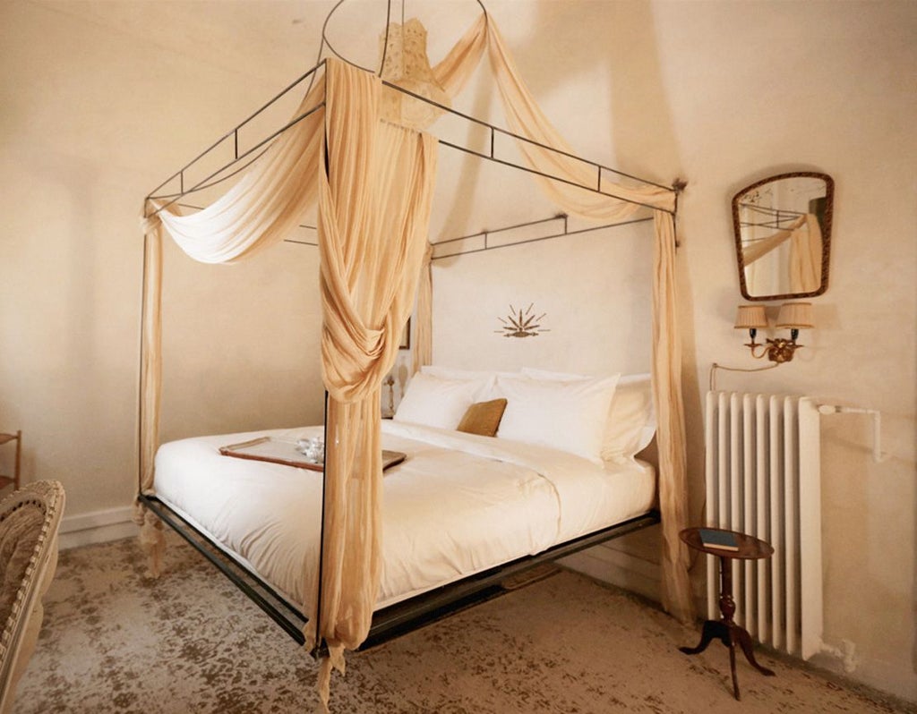 Elegant Athens hotel room with soft dust-rose accent walls, luxurious white bedding, and minimalist design showcasing contemporary Greek hospitality