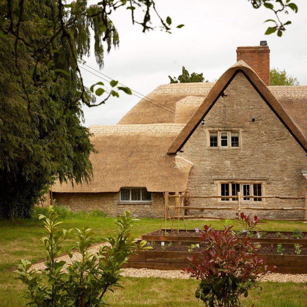 Rustic chic boutique hotel nestled in Oxfordshire countryside, featuring stone walls, elegant interiors, and warm natural lighting through large windows