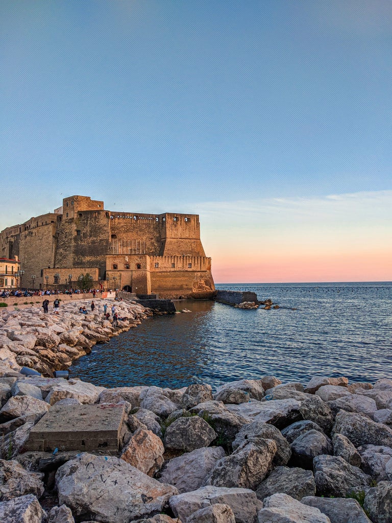 Iconic Gulf of Naples panoramic view with Mount Vesuvius towering over elegant yachts and luxury villas along the crystal-blue coastline