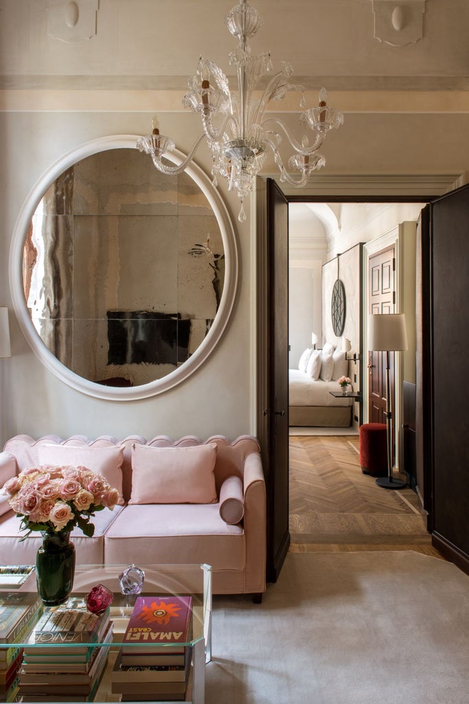 Historic 17th-century hotel in Paris with elegant stone facade, blue-gray shutters, ornate windows, and lush courtyard garden reflecting classic French architectural style.