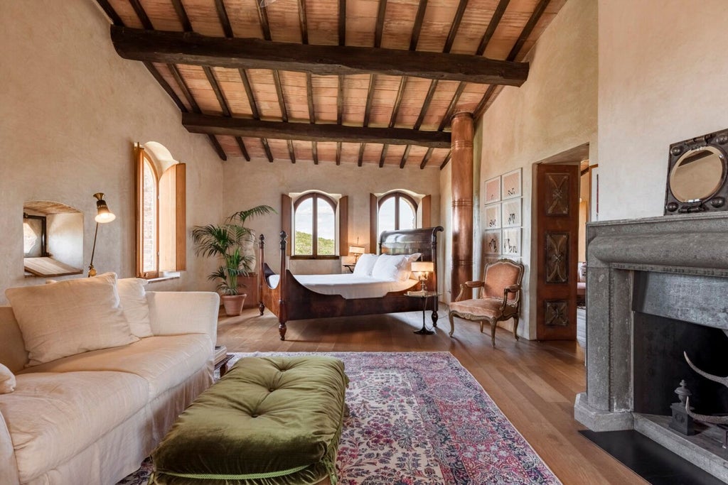 Elegant stone-walled luxury suite with rustic wooden furnishings, plush white bedding, and panoramic Tuscan countryside views through arched windows