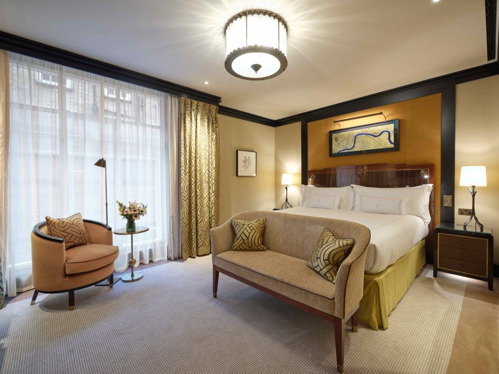 Elegant classic hotel room in Mayfair, London, featuring plush ivory furnishings, refined wooden accents, and sophisticated neutral color palette