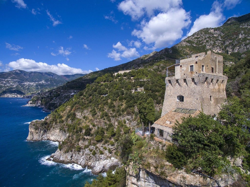 Cliffside medieval watchtower villa with cascading gardens, lemon groves and sea views, featuring elegant antique-furnished l