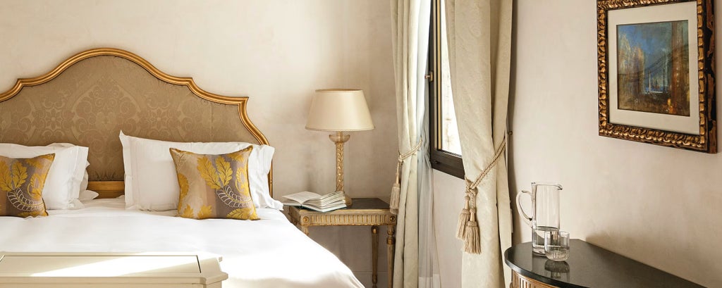 Elegant superior hotel room with French doors opening to private garden patio, featuring classical Venetian decor and marble bathroom