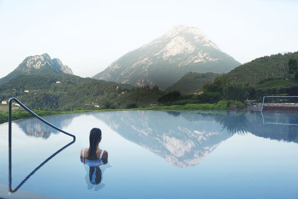 Luxurious lakeside resort built into Italian hillside with infinity pool overlooking Lake Garda's pristine waters and mountain views