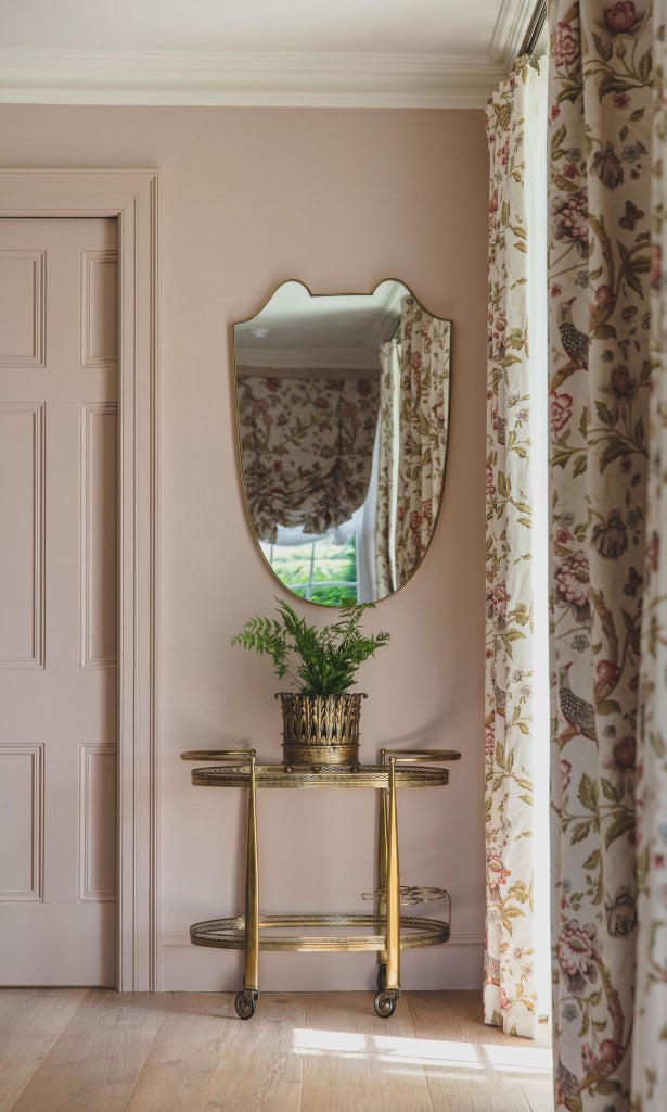 Elegant hotel room with soft English rose tones, rich cedar wood accents, luxurious white linens, and a sophisticated pale green color palette