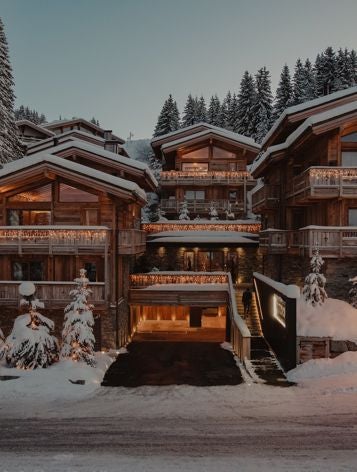 Luxurious ski chalet nestled in snow-covered French Alps, featuring modern alpine architecture with expansive windows and elegant stone facade.