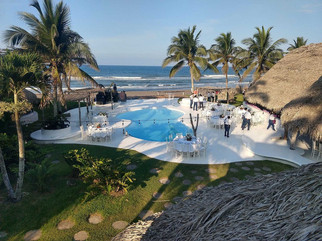 Luxury boutique Hotel Azúcar perched on a tropical cliff overlooking turquoise Mexican coastline with pristine white architecture and lush palm trees