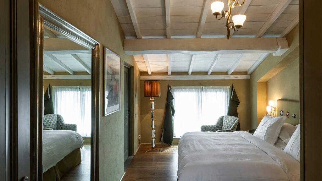 Elegant rustic Italian hotel room with warm wood tones, crisp white linens, and soft natural light streaming across minimalist furnishings.