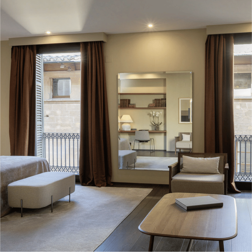 Elegant stone facade of Can Alomar boutique hotel in Mallorca, featuring ornate balconies, tall windows and classical Mediterranean architecture