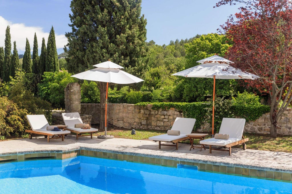 Elegant stone Provence hotel nestled near historic abbey, lush green gardens, sunlit terrace with refined French countryside charm and architectural beauty