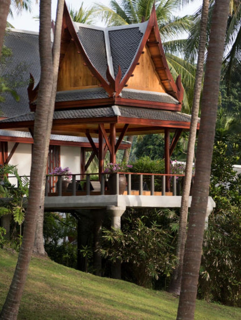 Luxurious pavilion bedroom with king bed, floor-to-ceiling windows opening to private pool and partial ocean views in tropical setting