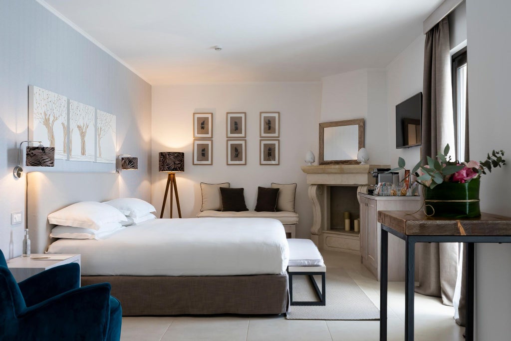 Spacious executive suite with modern white decor, plush king bed, floor-to-ceiling windows overlooking Italian coastal landscape at Canne Bianche Lifestyle Hotel