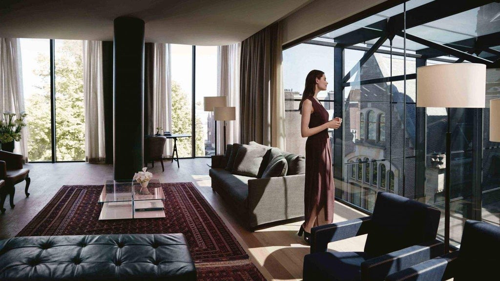 Luxurious penthouse suite with modern Amsterdam design, floor-to-ceiling windows overlooking cityscape, sleek furniture, and elegant minimalist interior.