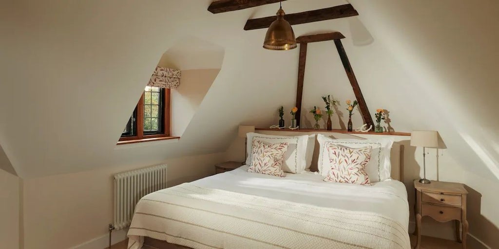 Elegant North Lodge room at Coworth Park, featuring plush white bedding, contemporary design, and soft natural light streaming through large windows.