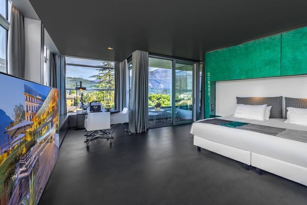 Elegant sky mountain suite with panoramic windows overlooking scenic Italian landscape, featuring modern minimalist design and luxurious king-sized bed