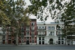 Elegant white-facade boutique hotel with modernist architecture, set in a historic building with lush palms in Valencia's city center