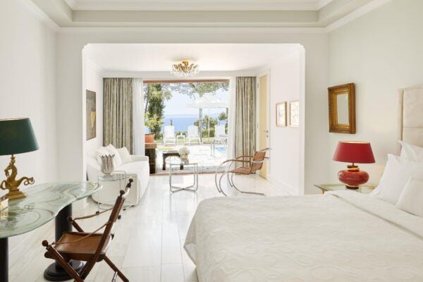 Luxurious two-bedroom suite with panoramic sea view, elegant wooden furnishings, and private balcony overlooking the Aegean coastline at Danai Beach Resort.