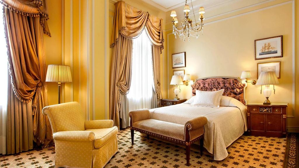 Grand marble facade of Hotel Grande Bretagne in Athens featuring neoclassical architecture, ornate balconies, and elegant period lighting