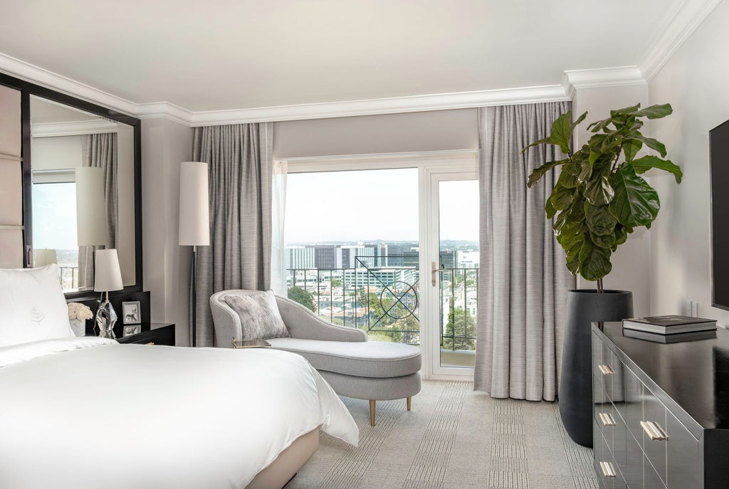 Elegant luxury hotel exterior with Mediterranean-style facade, palm trees and ornate entrance featuring beige stone and glass details